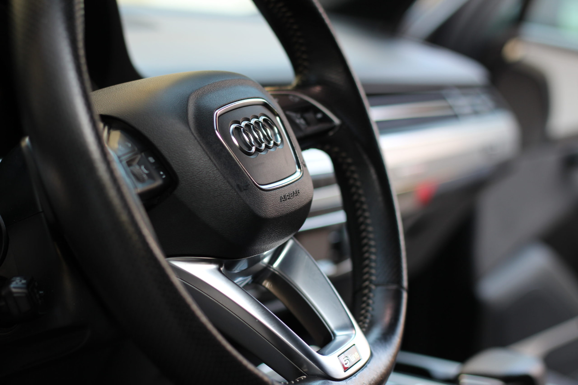 Detailgereinigtes Audi-Lenkrad mit Cockpit im Hintergrund